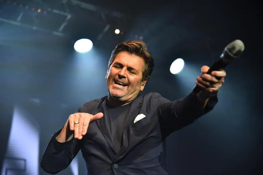 Thomas Anders se zvednutým mikrofonem baví publikum